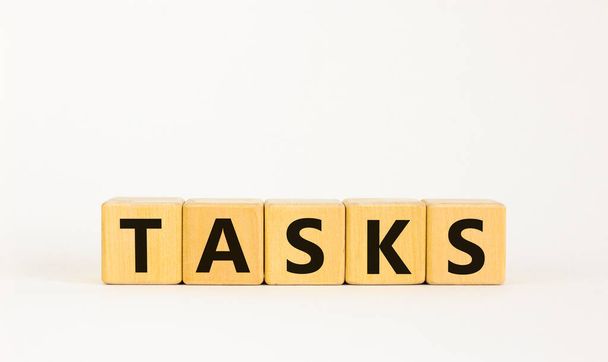 Tasks symbol. The concept word 'tasks' on wooden cubes on a beautiful white table. White background. Business and task or tasks concept. - Fotó, kép