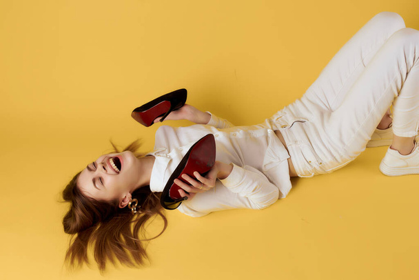 nő divatos ruhák cipő pózol stúdió sárga háttér - Fotó, kép