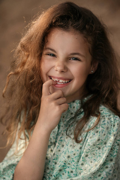 Closeup portrait of cute curly girl, blurred background  - Valokuva, kuva
