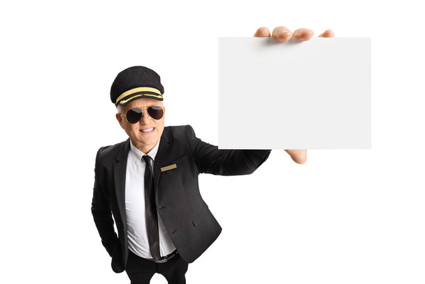 Chauffeur in a uniform and sunglasses showing a blank card in front of camera isolated on white background - Photo, image