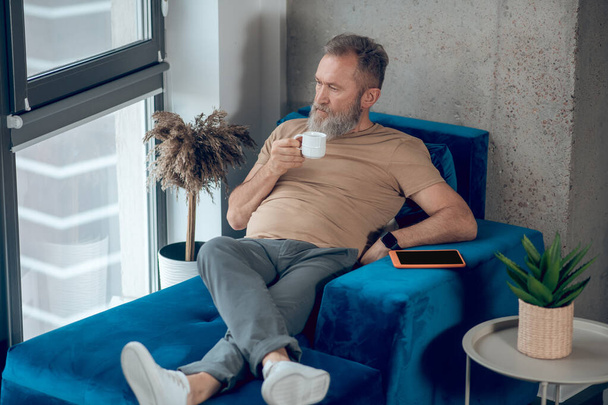 A man habving his morning coffee and looking relaxed - Foto, afbeelding