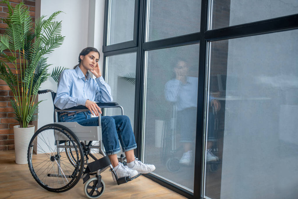 A young girl on a wheelchair looking frustrated and upset - Foto, afbeelding