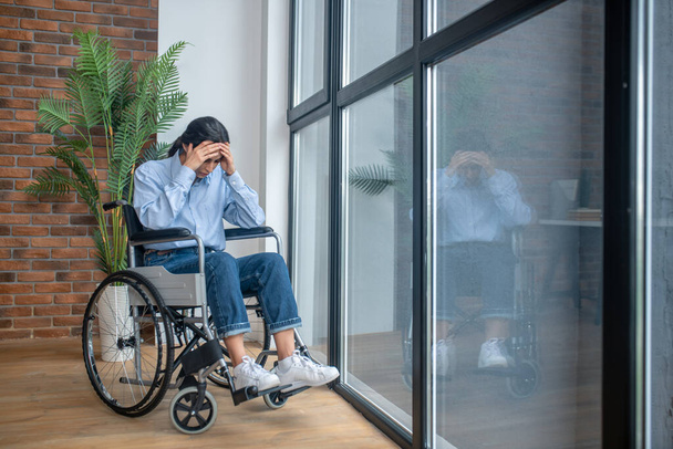 A young girl on a wheelchair looking frustrated and upset - Foto, Bild