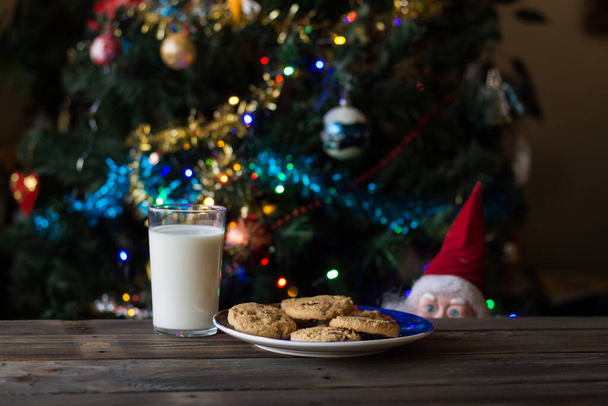 父クリスマスのおもちゃクッキーとミルクのガラスを見て. - 写真・画像