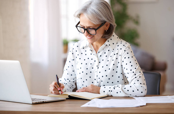 Onnellinen eläkkeellä eläkeläinen opiskelee verkossa kannettavan kotona - Valokuva, kuva