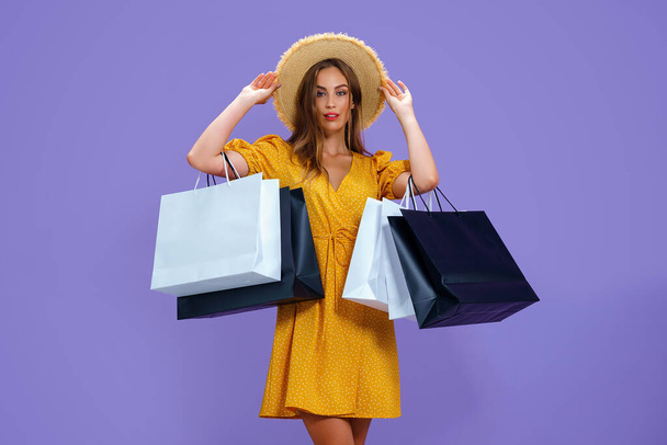 Módní dospělý dívka drží nákupní tašky na fialovém pozadí. prodej, nákupy, nakupování, Černý pátek - Fotografie, Obrázek