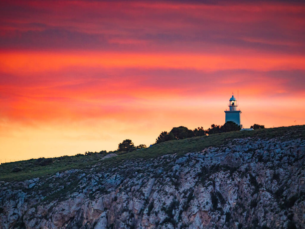 Sunset over spanish Costa Blanca coast with lighthouse on cliff, Spain Alicante province, Santa Pola region. - Фото, изображение