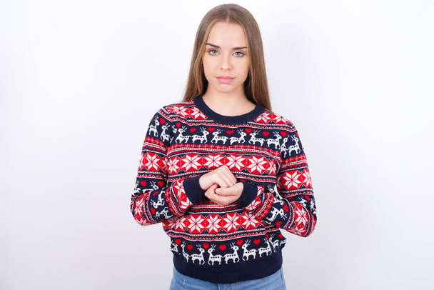 Фото веселой уверенной молодой белой девушки в рождественских свитерах на белом фоне вместе - Фото, изображение