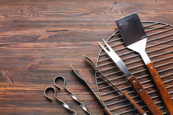 new metallic barbecue utensils wooden background - Foto, imagen