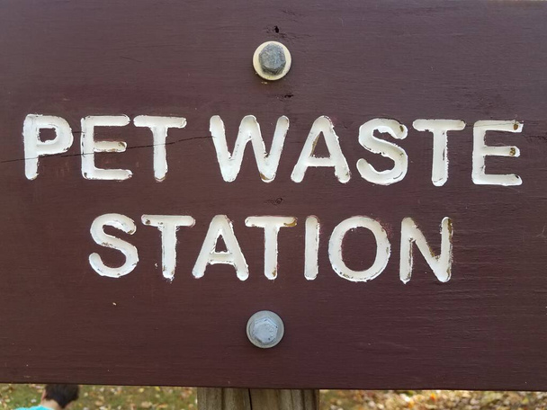 καφέ κατοικίδιο ζώο σταθμό αποβλήτων υπογράψει με λευκά γράμματα στο πάρκο - Φωτογραφία, εικόνα