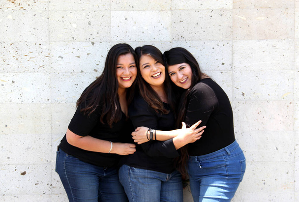 Feliz negro pelo liso latino hermanas adultas vestidas de negro para la sesión de fotos familiares en armonía y alegría - Foto, Imagen