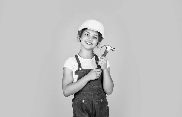 cheerful child laborer using building uniform and hammer tool, labor day - 写真・画像