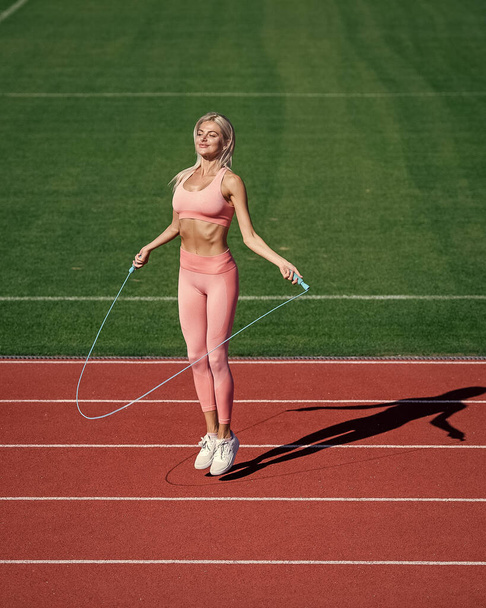 sexy fitness woman in sportswear. athletic lady use jumping-rope on stadium. female athlete do jumping sport workout. trainer or coach training with skipping rope. healthy and sporty - Φωτογραφία, εικόνα