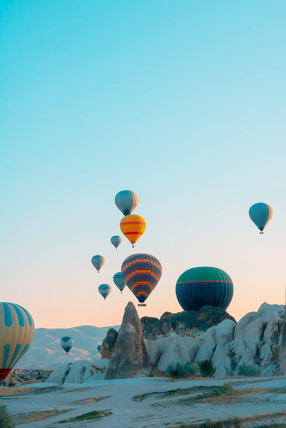 Hot air balloons and fairy chimneys in Cappadocia Turkey. Cappadocia background photo. Hot air balloon activity in Goreme.  - Valokuva, kuva