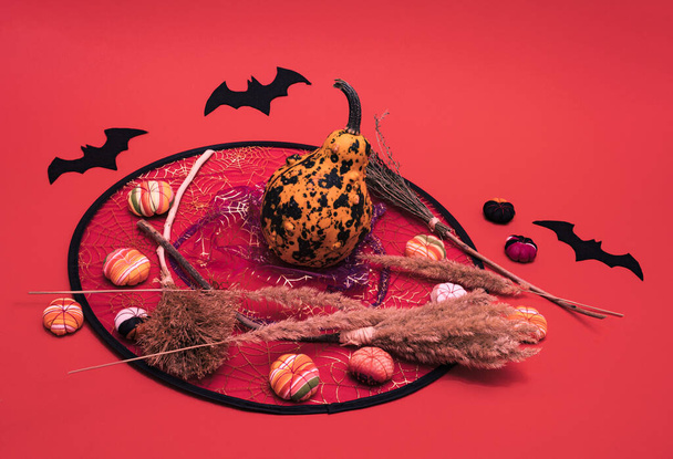 Witchs broomssticks and little rubber pumpkins  lay down on yellow and orange background. Square geometric flat lay composition, minimal halloween celebration concept. - Photo, Image