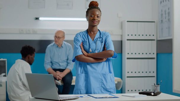 Muotokuva lääketieteen avustaja yllään univormu seisoo kaapissa - Valokuva, kuva