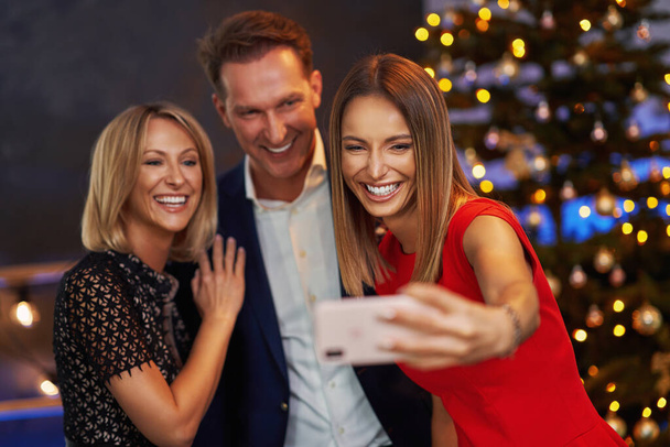 Amigos de negocios celebrando fiesta de Navidad tomando selfie - Foto, imagen