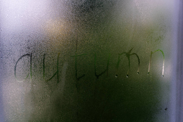 Ködös üveg az ablakon, írott ujjal Autumn. Koncepció fotó másolási hellyel - Fotó, kép