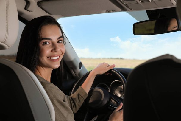 Beautiful young woman on driver's seat in modern car - Photo, image