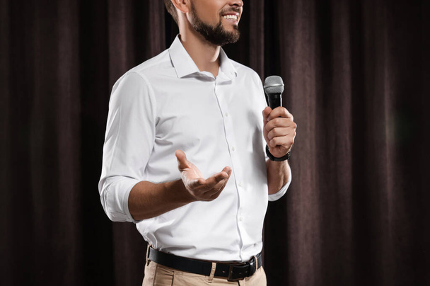 Motivational speaker with microphone performing on stage, closeup - Photo, Image