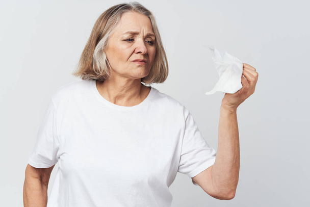 ηλικιωμένη γυναίκα σε λευκό t-shirt πόνο προβλήματα υγείας θεραπεία δυσαρέσκεια - Φωτογραφία, εικόνα
