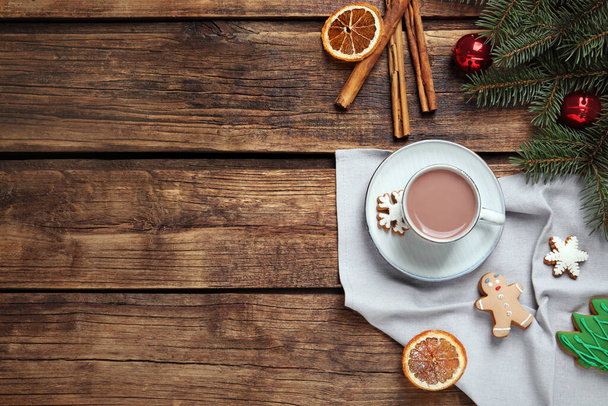 Flat lay composition with delicious hot chocolate and Christmas decor on wooden table, space for text - Foto, afbeelding