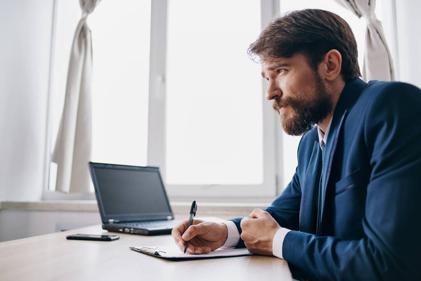 bearded man sitting at a desk in front of a laptop finance official - Foto, Imagem