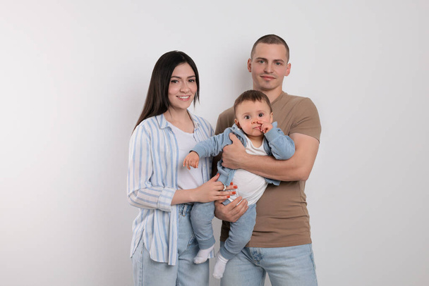 Portrait of happy family with little child on light background - Foto, Bild