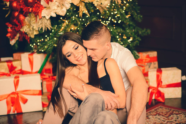 Мужчина удивляет женщину на Рождество, любящую и целующуюся пару - Фото, изображение
