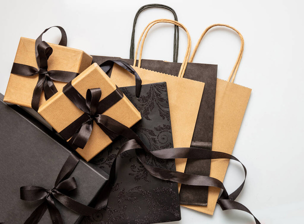 Black Friday sale concept, Gift boxes and shopping bags with tied ribbon bow on white background, top view, Winter season holiday promotion offer - Valokuva, kuva