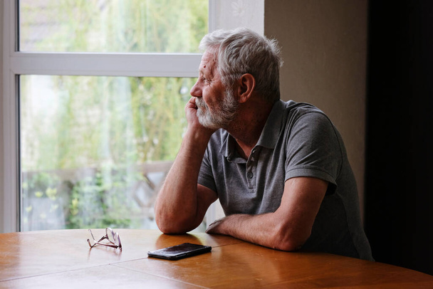 Senior retired man sitting at home alone while quarantine - Foto, immagini