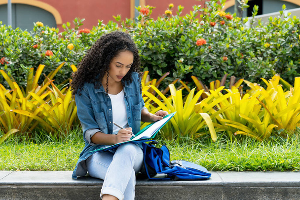 Brazilian female student learning at campus of university in summer - Fotoğraf, Görsel