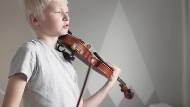 Niet tevreden en verontwaardigd jongen blond zonder verlangen om thuis te spelen op de viool - Video