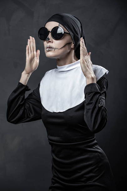 Sexy nun with halloween makeup over gray background - Фото, зображення