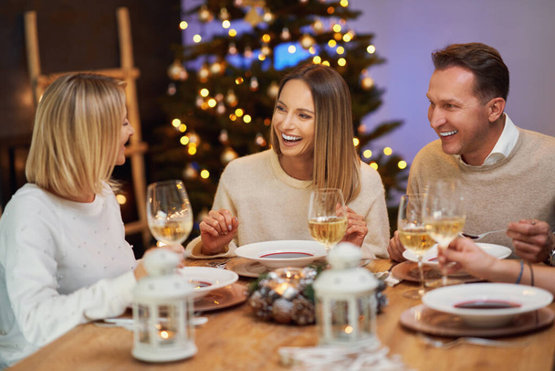 Amigos celebrando fiesta de Navidad celebrando vino - Foto, Imagen