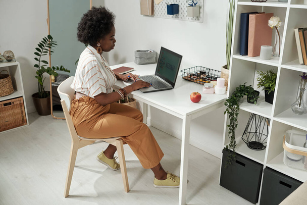 Young contemporary businesswoman networking by desk at home - Photo, Image