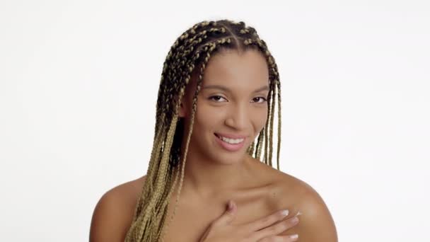 Mujer negra aplicando crema en hombro desnudo sobre fondo blanco - Metraje, vídeo