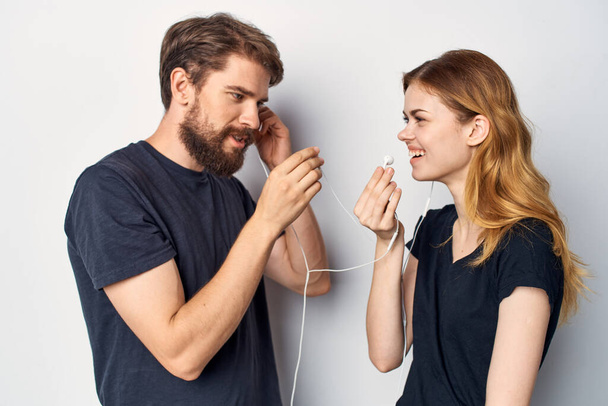 Homme et femme avec un téléphone dans la main émotions dans le fond de lumière casque - Photo, image