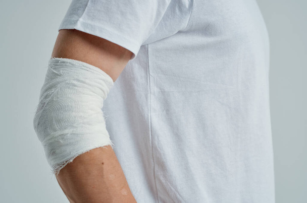 sick man in a white T-shirt with a bandaged hand hospital medicine - Fotoğraf, Görsel