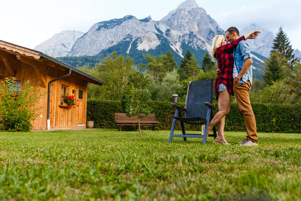 Młodzi miłośnicy relaksu na wakacjach w pięknej panoramie z górami Bawaria Niemcy. Para zakochanych relaksuje się wiosną - Zdjęcie, obraz