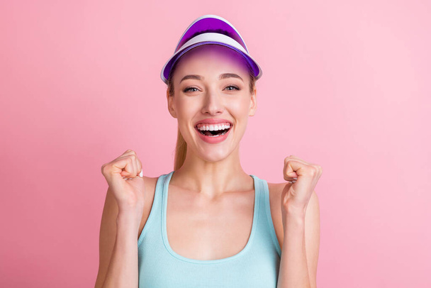 Photo of hooray blond young lady hands fists yell wear blue top visor isolated on pink color background - Foto, afbeelding