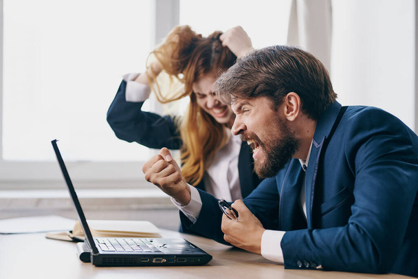 managers zitten achter een bureau met een laptop communicatie ambtenaren - Foto, afbeelding