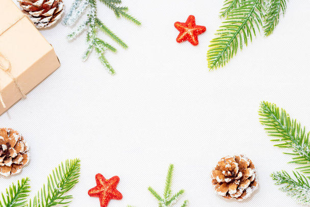 Cadeau de Noël boîte, cônes de pin, branches de sapin et étoile sur fond blanc. Pose plate, vue du dessus, espace de copie. - Photo, image