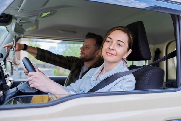 Middle age couple riding in car, woman driver man in passenger seat - Fotó, kép