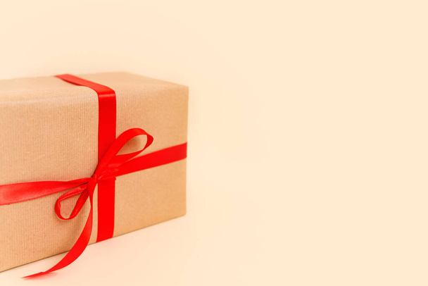 Vánoční dárková krabice s červenou mašlí na béžovém pozadí. Dovolená koncept, Nový rok dárky. Kvalitní fotografie - Fotografie, Obrázek