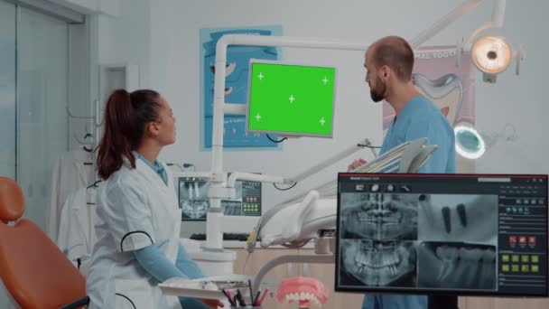 Dentista e assistente che guardano lo schermo verde sul monitor - Filmati, video