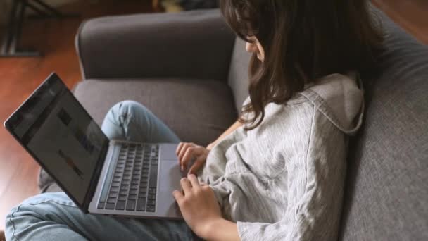 indoor portrait of pre-teen girl doing homework online or browsing internet, mdeia technologies, digital communication or shopping, teenager lifestyle - Footage, Video