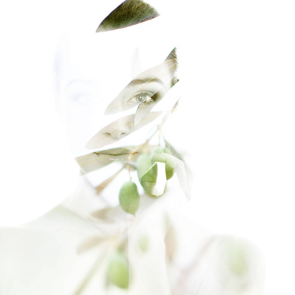 Beautiful woman with branch of olive tree, double exposure portrait. - Photo, image