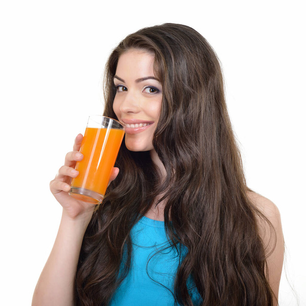 Young cheerful woman drinks orange juice with a pleasure, isolated on white background - Foto, immagini