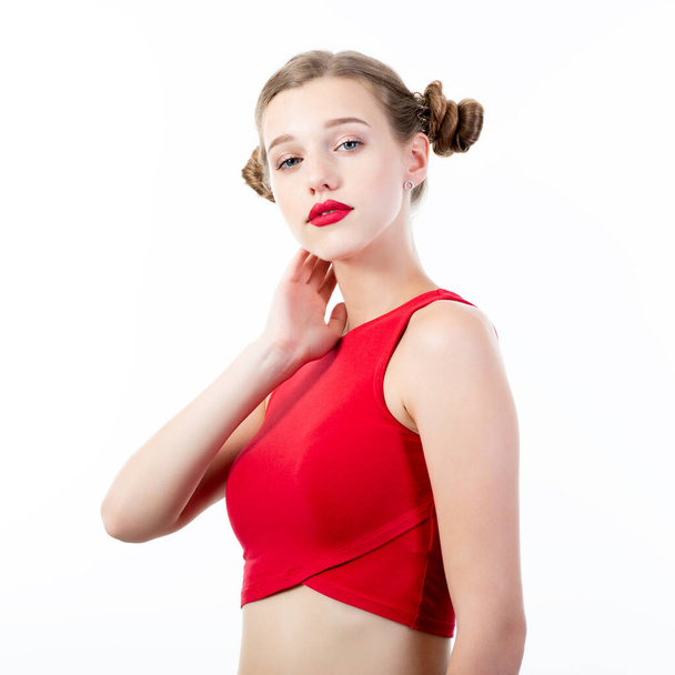 Young charming woman wearing red top posing at studio over white background - 写真・画像